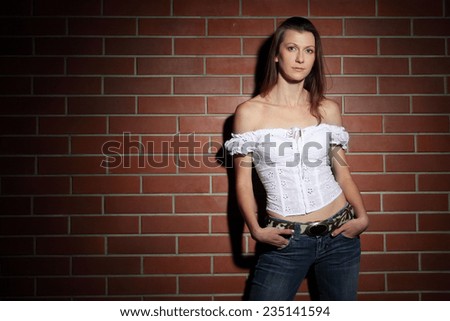 active beautiful fashion model posing on a background of a brick wall. slim figure, gorgeous clothes, beautiful look