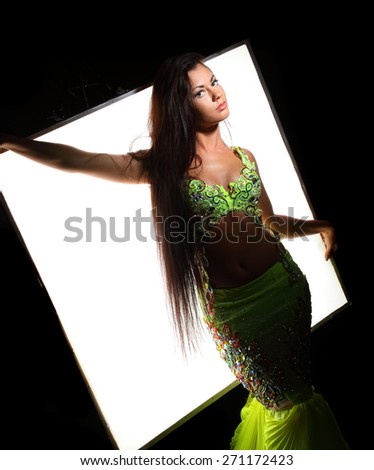 beautiful woman dancing in colorful Arabic dance costume.girl in an orange dress. beautiful brunette. long hair.