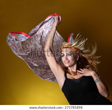 beautiful young woman with a scarf in the wind . on a yellow background. active model