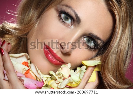 portrait of a young woman with petals of roses. beautiful emotions, good makeup
