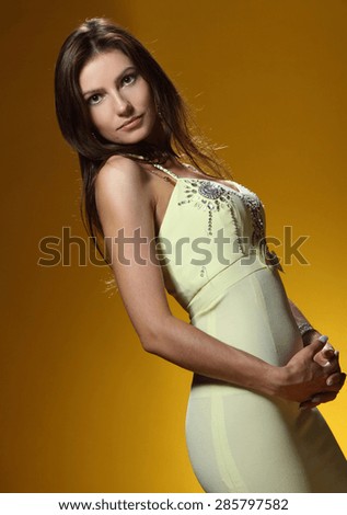 beautiful young woman on a yellow background. beautiful figure . vivid emotions, stylish makeover, sexy,  gorgeous long Hair