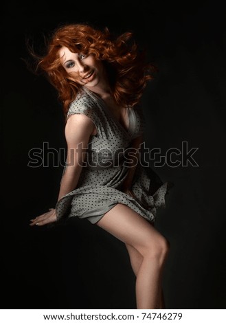 red-haired, blue-eyed girl in an emotional flight with the wind from the developing hair