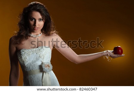portrait of a bride with a red apple on a yellow background