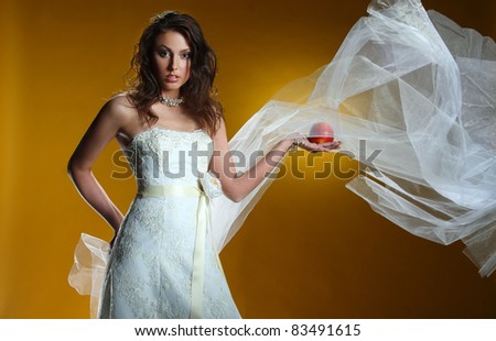 portrait of a bride with a red apple on a yellow background