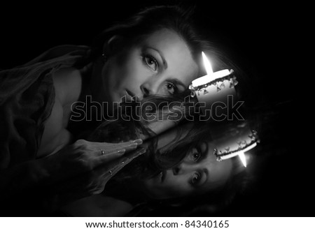 portrait of a beautiful woman with a candle on a black background