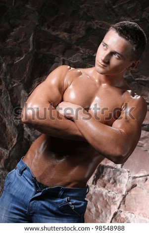 muscular man in blue jeans and an athletic, brilliant torso