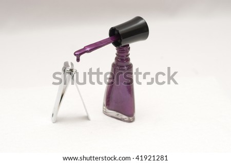 Nail clipper and purple nail polish dripping from brush, isolated on white
