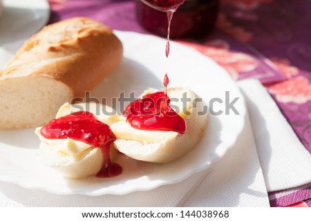 tasty fresh white bread with butter and raspberry jam
