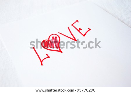 The word love written by bright red ink on a clean sheet of a paper