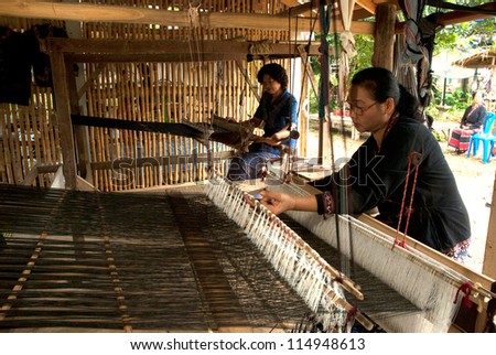 NAN,THAILAND - SEPTEMBER 25 : Hill  tribe woman weaving on September 25, 2011 in hill tribe village, Nan province,Thailand. Hill tribe women are minority of Thailand exploited for tourism reasons .