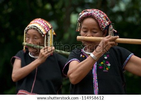 NAN, THAILAND - SEPT 29 : Khmu old woman with traditional clothes and silver  on neck and she used nose playing a bamboo flute in hill  tribe minority village on September 29, 2011 in Nan, Thailand.
