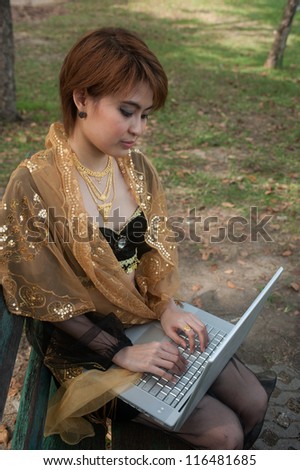 Pretty woman working with laptop in the park.