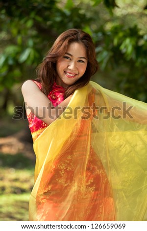 Pretty Chinese  woman in  traditional dress in a cheerful manner.