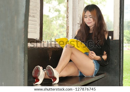 Asian woman reading in old train room .