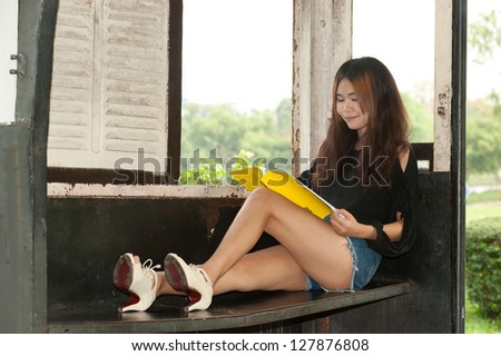 Asian woman reading in old train room .