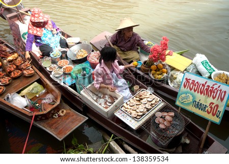 SAMUTSONGKRAM,THAILAND-SEPT 6 : Local vendor selling food at Amphawa evening floating Market famous floating market and cultural tourist destination on September  6, 2012 in Samutsongkram, Thailand.