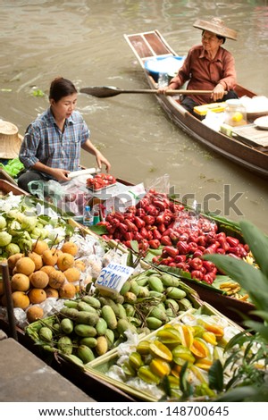 RATCHABURI,THAILAND -JUL 21:Local merchant sell food ,fruits and product at Damnoen Saduak floating market,on July 21,2013 in Ratchaburi,Thailand .Dumnoen Saduak is a very popular tourist attraction.