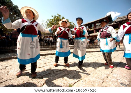 LIJIANG, CHINA - MAR 17:A group of Naxi nationality old women dressed in national clothing dancing. Located in Lijiang Dayan Old Town Square Street (Sifang Street) on March 17,2014,Yunnan in China.