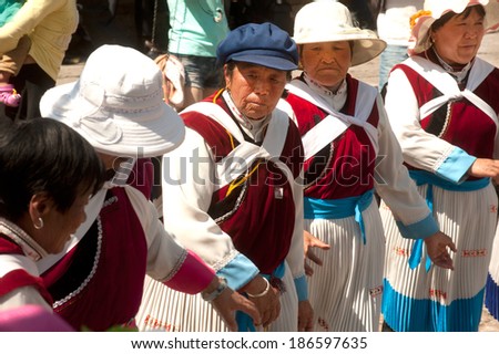LIJIANG, CHINA - MAR 17:A group of Naxi nationality old women dressed in national clothing dancing. Located in Lijiang Dayan Old Town Square Street (Sifang Street) on March 17,2014,Yunnan in China.