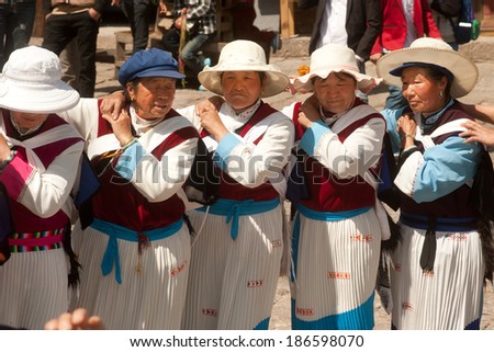 LIJIANG,CHINA-MARCH 17: A group of Naxi nationality old woman dressed in national clothing dancing.Located in Lijiang Dayan Old Town Square street (Sifang Street) on March 17,2014,Yunnan in China.