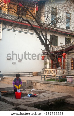 LIJIANG,CHINA Ã¢Â?Â? MARCH 17 : The daily lives of Naxi woman washing on ancient pool is White horse Dragon at Dayan old town on March 17, 2014 in  Lijiang city,Yunnan province,Southwestern of China.