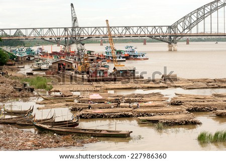 AMARAPURA,MYANMAR-JULY 1 : Bamboo raft on port activities in Ayeyarwaddy river opposite Sagaing and Inwa bridge in background on July 1,2014, Amarapura city in Central of Myanmar.