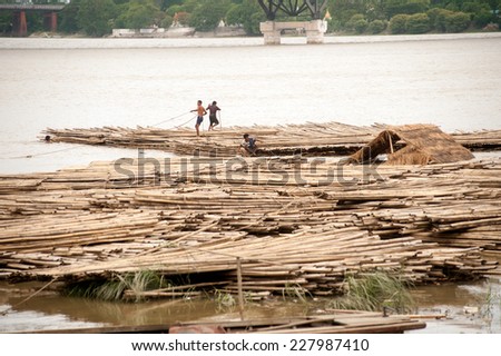 AMARAPURA,MYANMAR-JULY 1 : Bamboo raft on Port activities in Ayeyarwaddy river for sell on July 1,2014 in Amarapura city in Central of Myanmar.