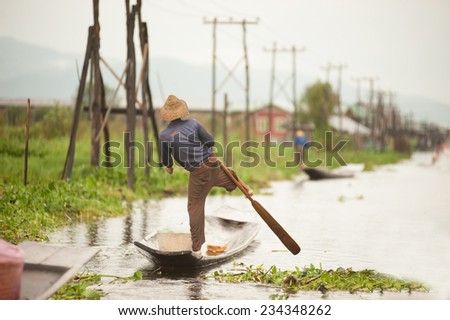 INLE,MYANMAR-SEPTEMBER 29 : Man Paddle by leg on September 29,2014 at Inle Lake,Shan state in Myanmar.Intha monority people paddle with leg-rowing style unique the one in the World.