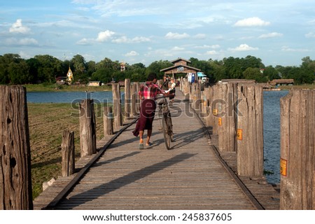 AMARAPURA,MYANMAR - JUNE 30 : Residents and visitors traveling walking on U Bein Bridge on June 30,2014,Amarapura in Myanmar.U Bein Bridge is the oldest and longest teak wooden bridge in the world.