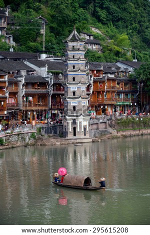 FENGHUANG, CHINA - JUNE 9 : Young minority singing show for tourist in river every day in Fenghuang old town on June 9, 2015 in nghuang,China.This ancient town was added to the UNESCO World Heritage.