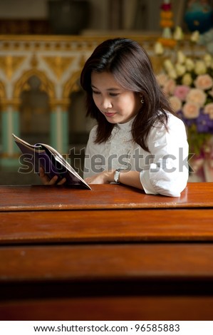 Pretty Thai woman study bible in Christian church .