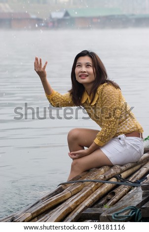 Pretty Asian woman playing water in floating house .