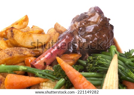 Lamb Shank in a Rosemary and Red Wine Jus with vegetable on a white plate