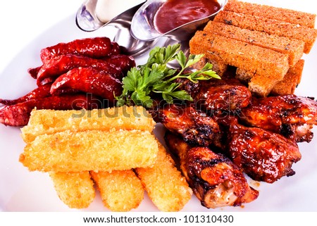 Meat dish with various meats, chicken, sausage, toast, potatoes.