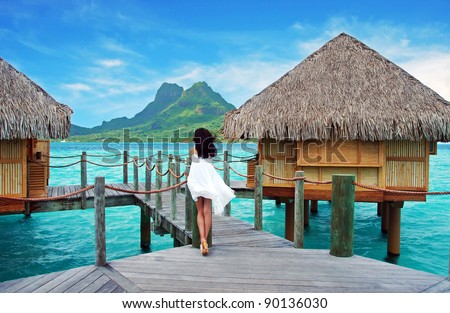 Young lady stand alone , look towards to the Otemanu mountain at Bora Bora island , French Polynesia , Pacific ocean .