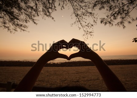silhouette love hand sign on sunset moment