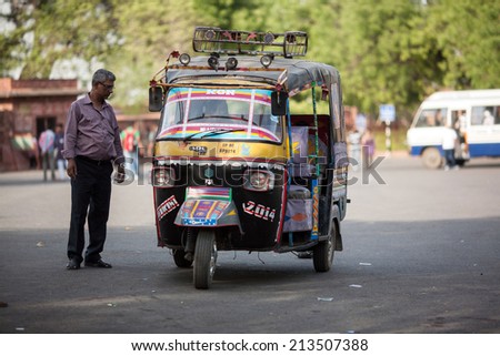 AGRA, INDIA - APRIL 12: Unidentified man with three wheel car, which the public car transportation in call \'auto rickshaw\' on Apr 12, 2014 in Agra, India.