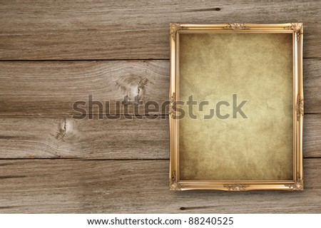 gold portrait frame on old wooden background