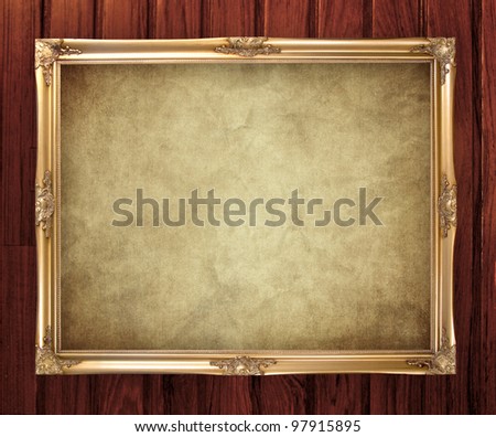 gold portrait frame on old wooden background