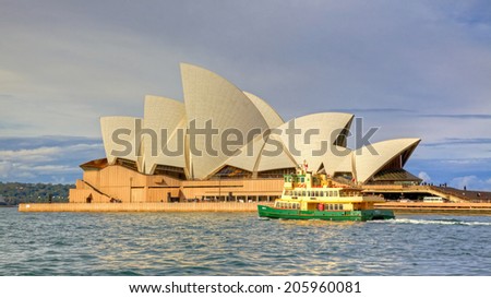 SYDNEY, AUSTRALIA - MAY 20, 2010: A ferry passes Sydney Opera House, Australia\'s most recognisable building, on its way from Circular Quay.