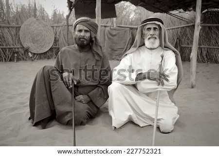 DUBAI - MARCH 8, 2005: Two Arab men at their camp near Dubai. The older man on the right is blind. Black and white image.