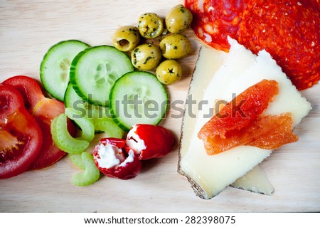 Spanish salad comprising of sliced chorizo, manchego cheese topped with quince jam, peppadew peppers stuffed with soft cheese accompanied by cucumber and tomato.