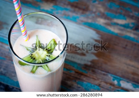 Smoothie milkshake made from peach,melon and papaya blended with kefir yogurt and topped with fresh kiwi fruit.