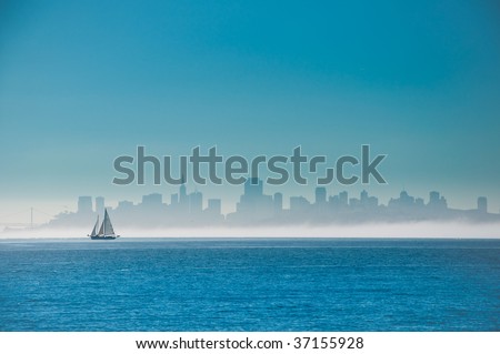 Yacht sailing on San Francisco Bay with the city skyline behind.
