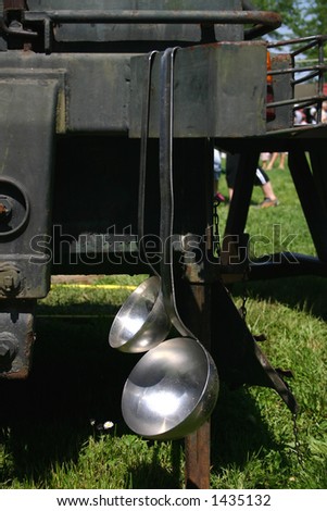 Giant soup-ladles hanging down from a military equipment.
