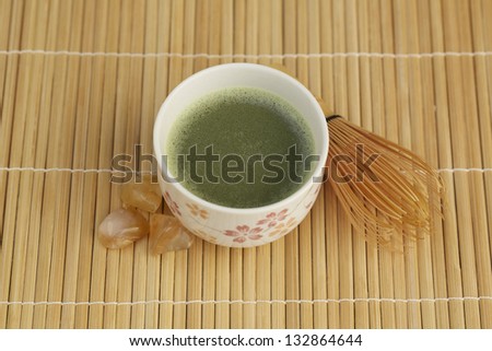 Close up of Japanese green tea on bamboo plate mat.
