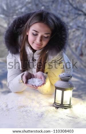 beautiful girl on winter forest with lantern