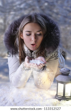 beautiful girl on winter snow with lantern