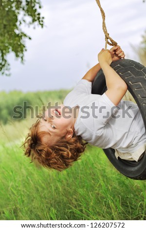 happy boy on swing outdoors