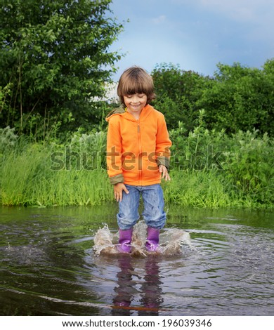 happy boy jump in puddle